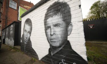 A mural depicting Liam and Noel Gallagher by artist Snow Graffiti adorns a wall at the Coach and Horses pub in Whitefield on October 21