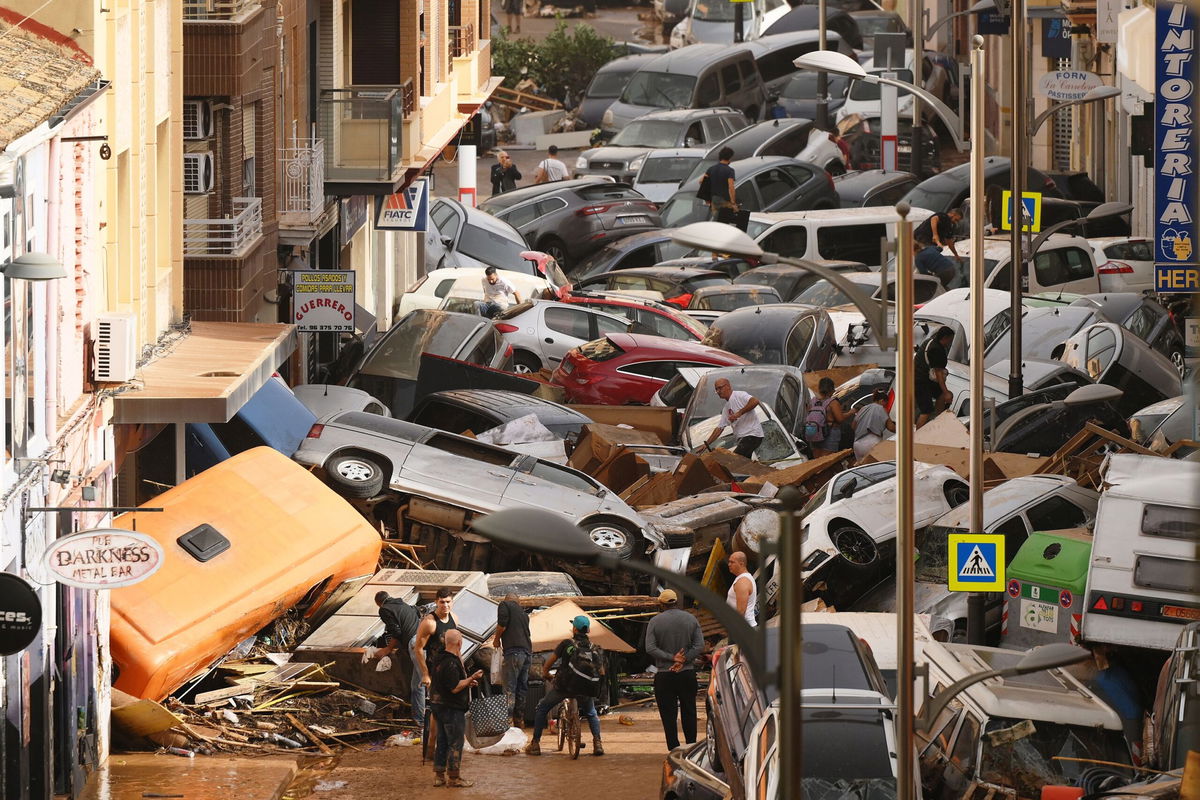 <i>Eva Manez/Reuters via CNN Newsource</i><br/>Damaged cars are seen along a road affected by torrential rains that caused flooding