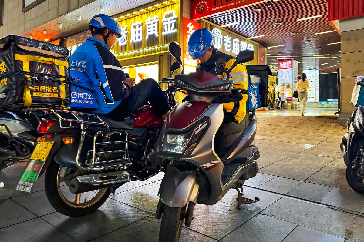 <i>Justin Robertson/CNN via CNN Newsource</i><br/>Food delivery worker Yang (left) speaks to CNN about his plight.