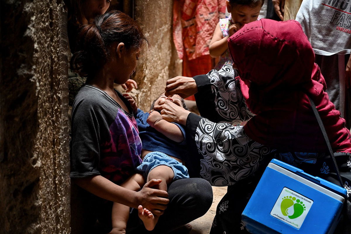 <i>K.M. Chaudary/AP via CNN Newsource</i><br/>A health worker administers a polio vaccine to a child in a downtown area of Lahore