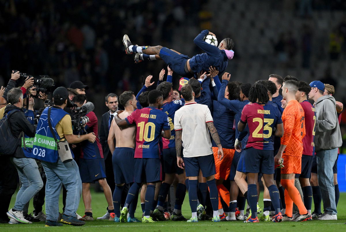 <i>David Ramos/Getty Images via CNN Newsource</i><br/>Raphinha is thrown in the air by his Barcelona teammates after scoring a hat-trick against Bayern Munich.