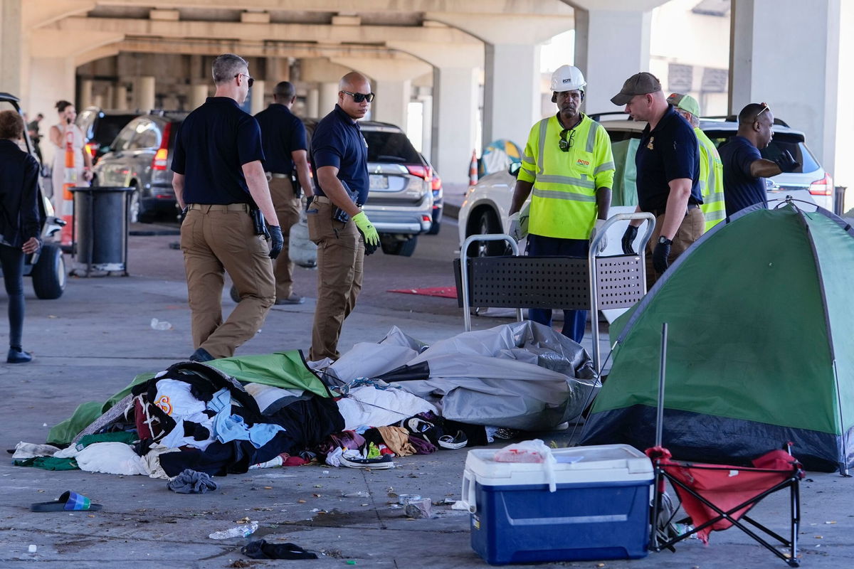 <i>Gerald Herbert/AP via CNN Newsource</i><br />Louisiana State police give instructions to people living in a homeless encampment to move to a different pre-designated location as they perform a sweep in advance of a Taylor Swift concert in New Orleans