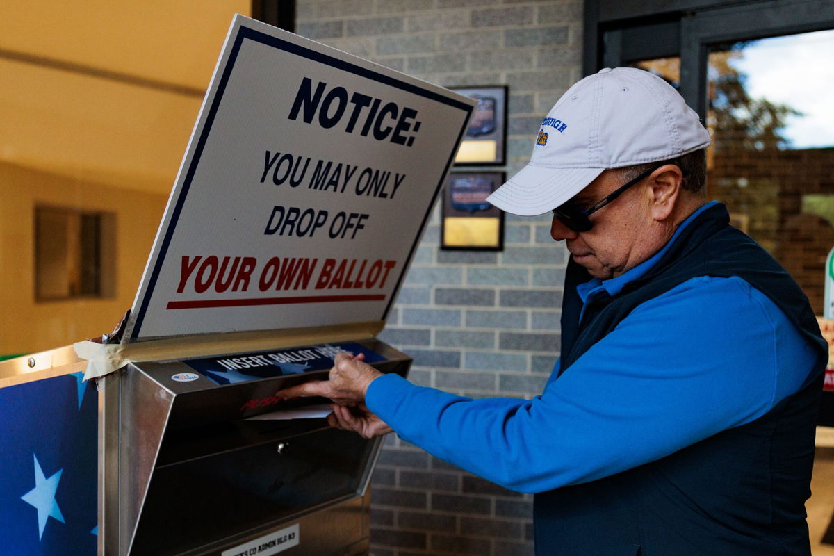 <i>Hannah Beier/Getty Images via CNN Newsource</i><br/>Diego Proano drops off a mail-in ballot on October 15