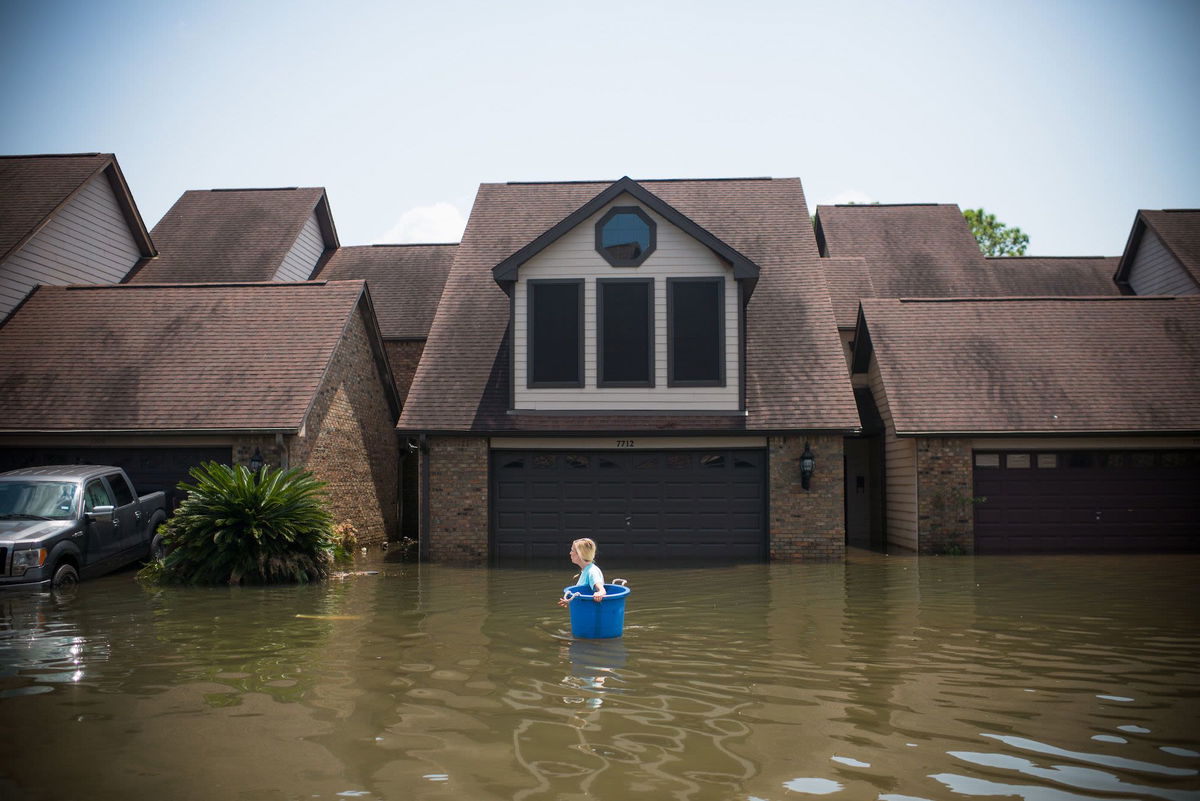 <i>Emily Kask/AFP/Getty Images via CNN Newsource</i><br/>Jenna Fountain carries a bucket to recover items in Port Arthur