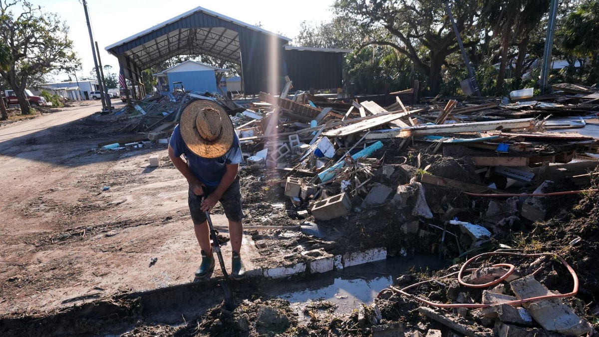 Chris Jordan, maintenance manager for Horseshoe Beach, tries to find a water shutoff valve in the aftermath of Hurricane Helene, Sept. 29, 2024.