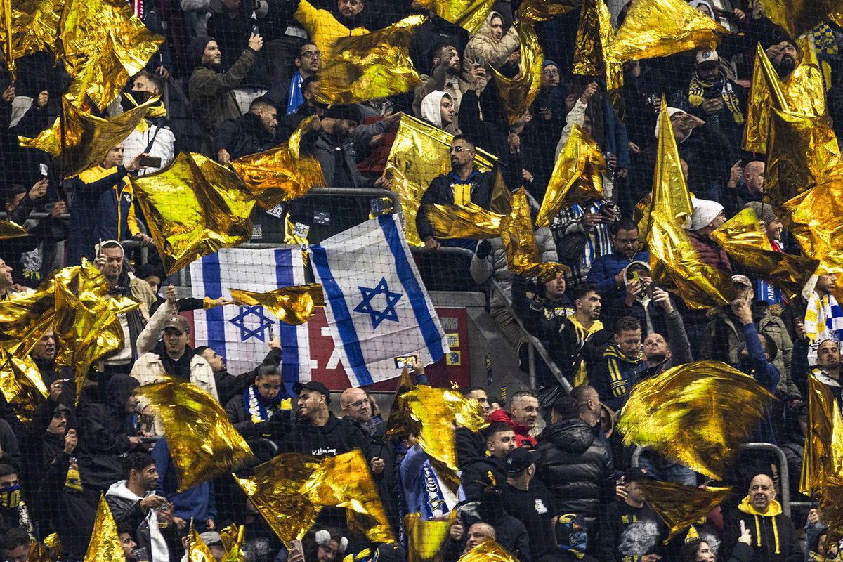 <i>Robin van Lonkhuijsen/AFP/Getty Images via CNN Newsource</i><br/>Maccabi supporters wave yellow flags next to Israeli flags during the UEFA Europa League football match between Ajax Amsterdam and Maccabi Tel Aviv at the Johan-Cruijff stadium