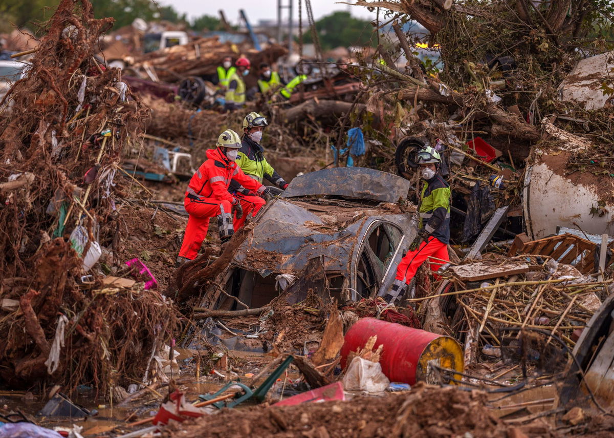 <i>Bruna Casas/Reuters via CNN Newsource</i><br/>Search and rescue team members look for bodies following flooding in Chiva