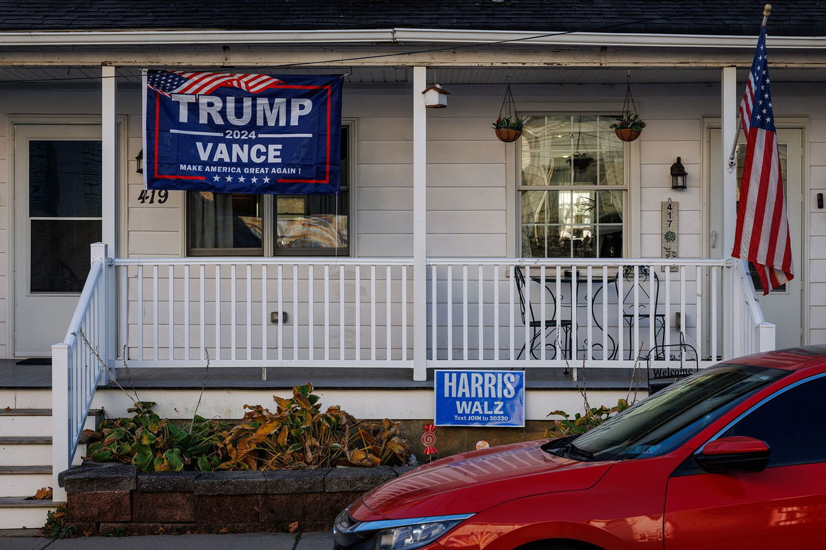 <i>Samuel Corum/AFP/Getty Images via CNN Newsource</i><br/>A Trump/Vance campaign flag hangs in front of one side of a duplex home while a Harris/Walz campaign sign is seen in front of the other side in Pen Argyl