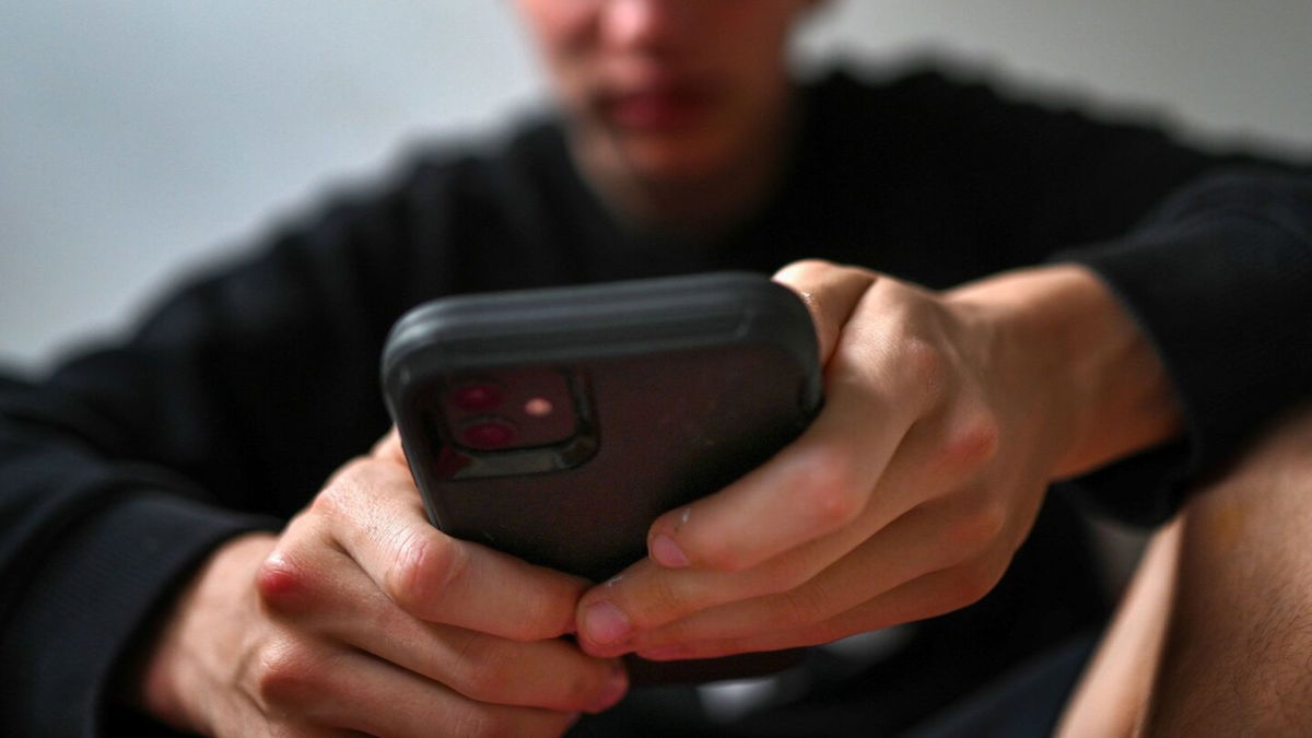 <i>Dean Lewins/AAP Image/AP via CNN Newsource</i><br/>A teenager uses his mobile phone to access social media