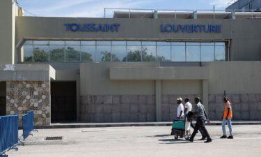 Travelers walk in front of the Toussaint Louverture International Airport in Port-au-Prince in May 2024.