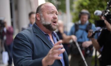 Alex Jones speaks to the media after arriving at the federal courthouse for a hearing in front of a bankruptcy judge