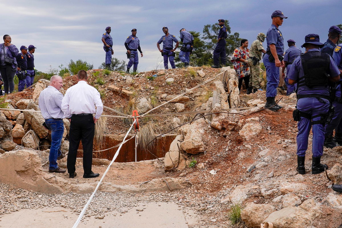 <i>Jerome Delay/AP via CNN Newsource</i><br/>Relatives of miners and community members wait near the shaft of the mine.