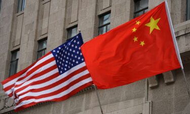 The national flags of the United States and China flutter at the Fairmont Peace Hotel on April 25