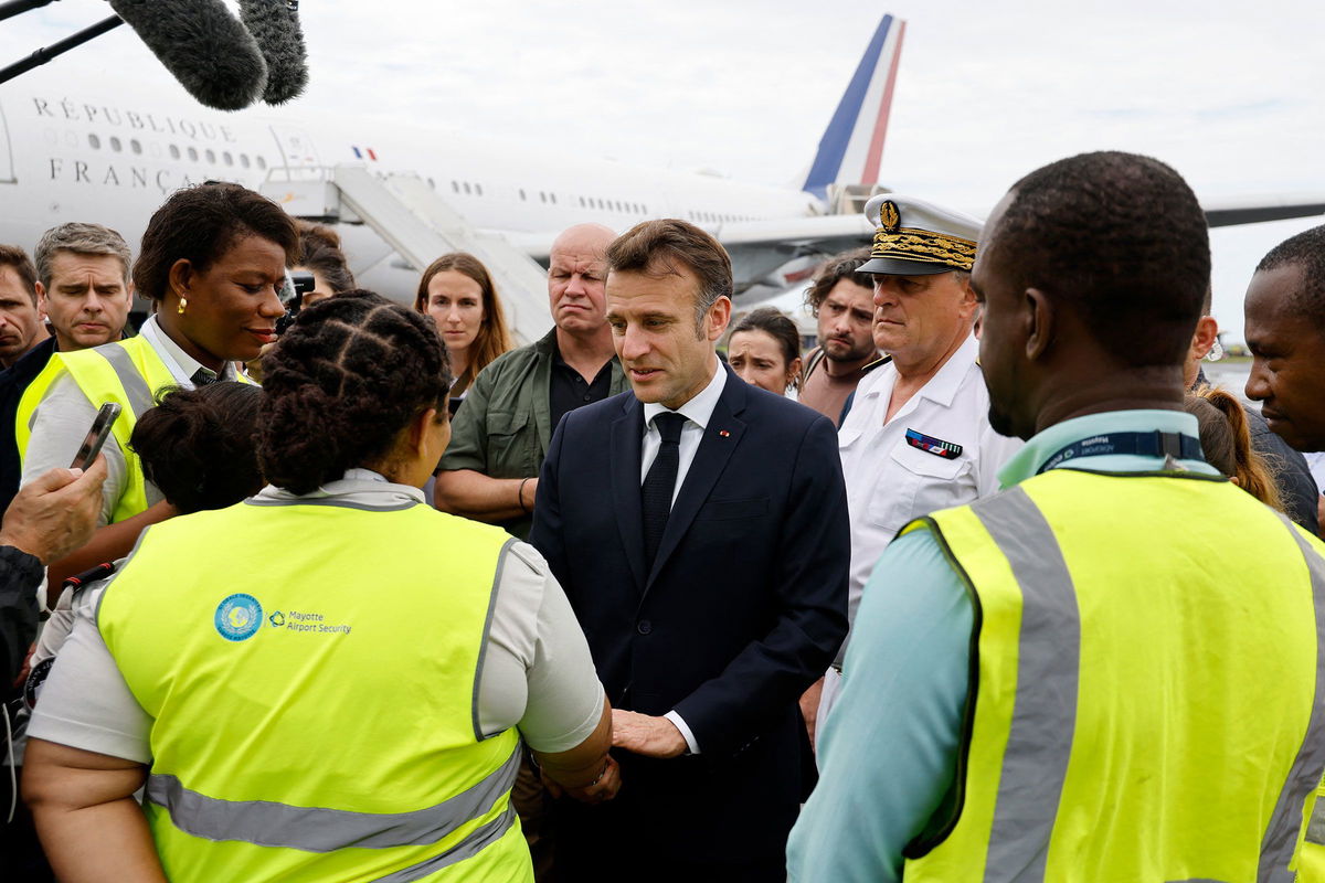 <i>Ludovic Marin/Pool/AFP/Getty Images via CNN Newsource</i><br/>French President Emmanuel Macron speaks with staff members as he arrives on the tarmac of Dzaoudzi's airport