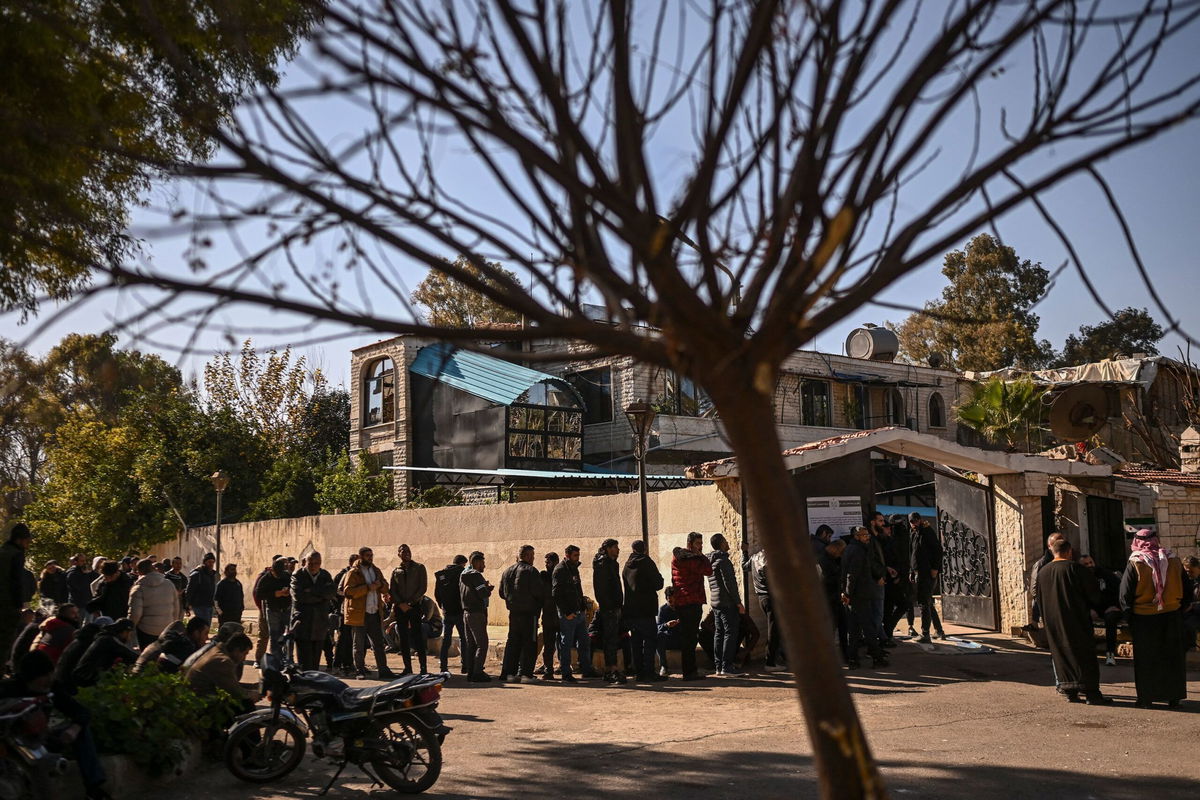 <i>Aris Messinis/AFP via Getty Images via CNN Newsource</i><br/>Syrian soldiers and police officers line up to register at a center in Daraa