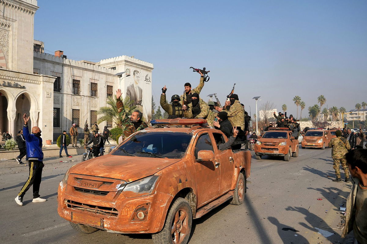 <i>Muhammad Haj Kadour/AFP/Getty Images via CNN Newsource</i><br />Residents cheer as the rebels pour into the captured city of Hama on Friday