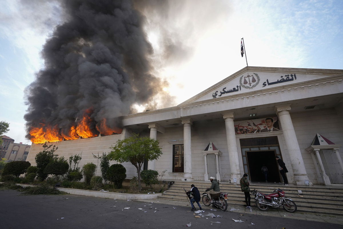 <i>Hussein Malla/AP via CNN Newsource</i><br/>Opposition fighters burn a military court in Damascus