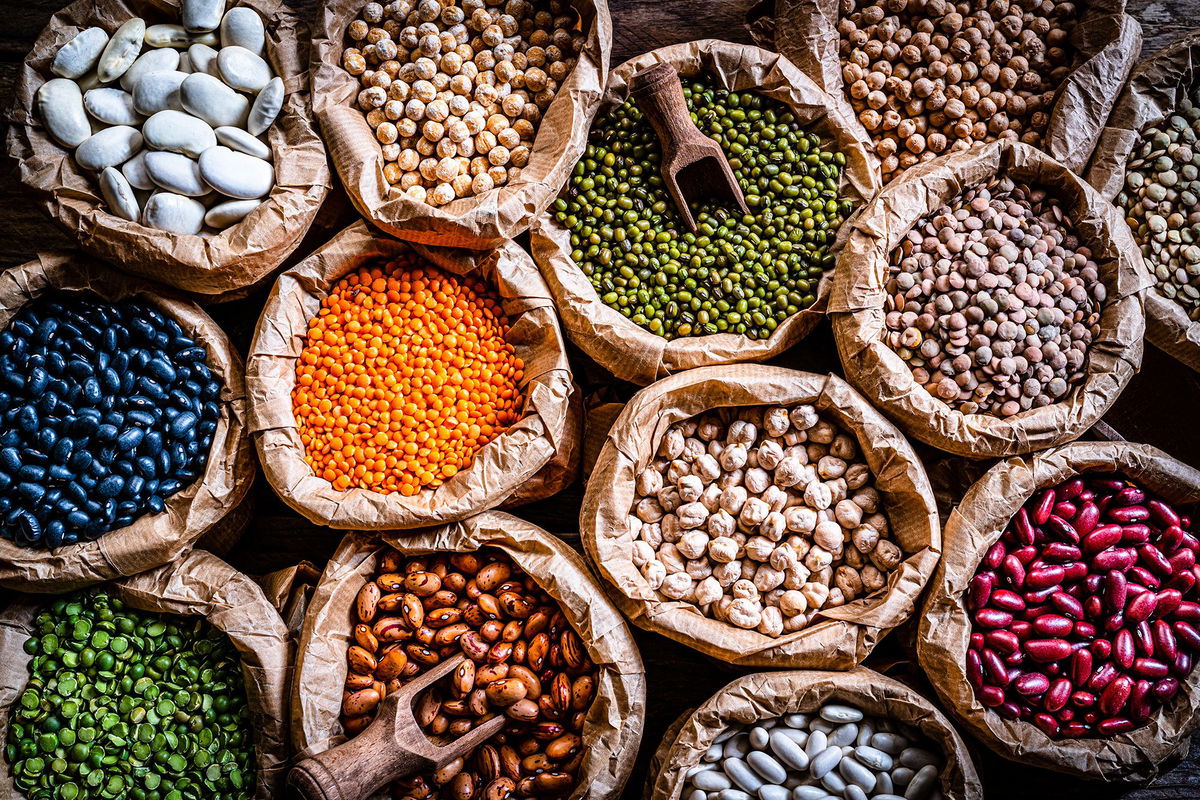 <i>fcafotodigital/E+/Getty Images via CNN Newsource</i><br/>Food Backgrounds: overhead view of several sacks filled with a large variety of dried beans and legumes. The composition includes green