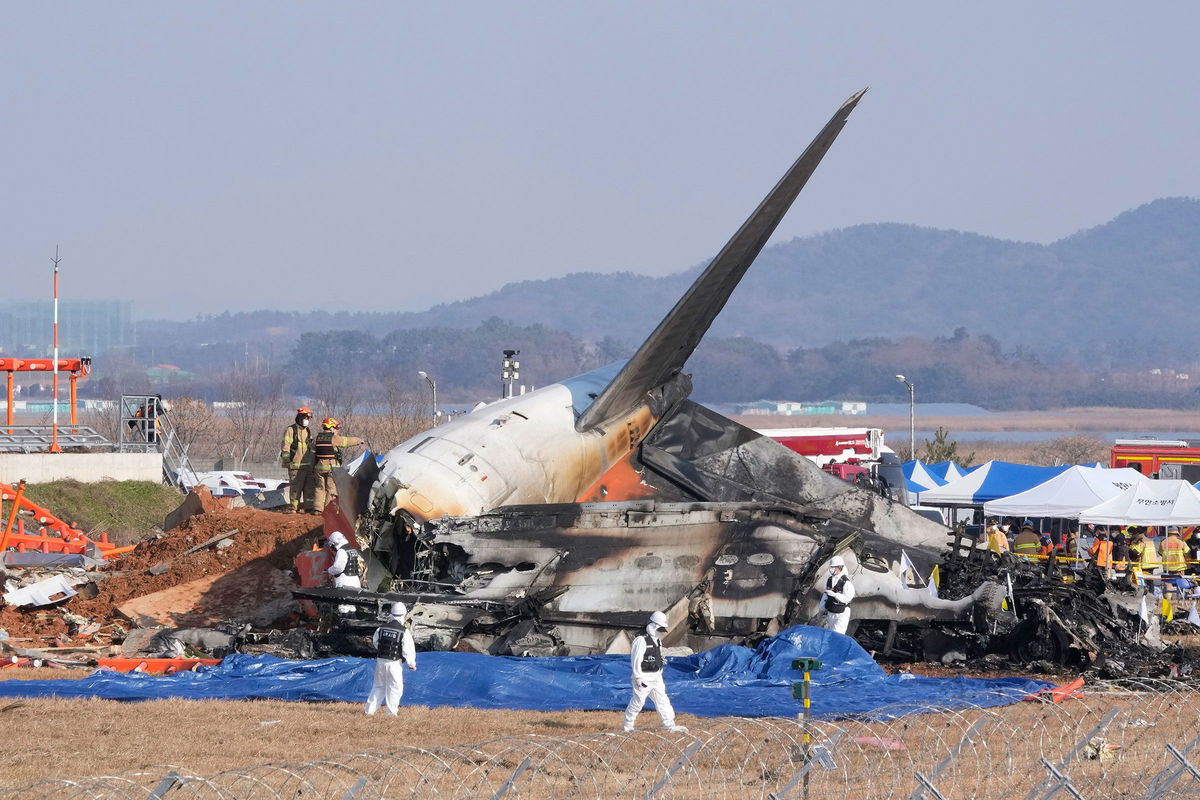 <i>Ahn Young-joon/AP via CNN Newsource</i><br/>Firefighters and rescue team members work near the wreckage of a passenger plane at Muan International Airport in South Korea on December 29.