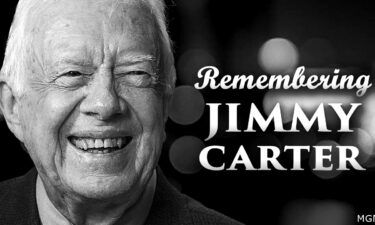 A photo of President Jimmy Carter smiling, featuring the words "Remembering Jimmy Carter"