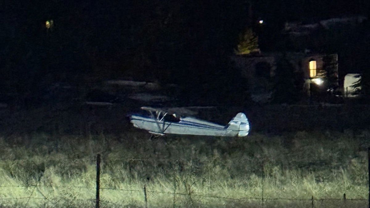 The plane sitting in a field next to Highway 105