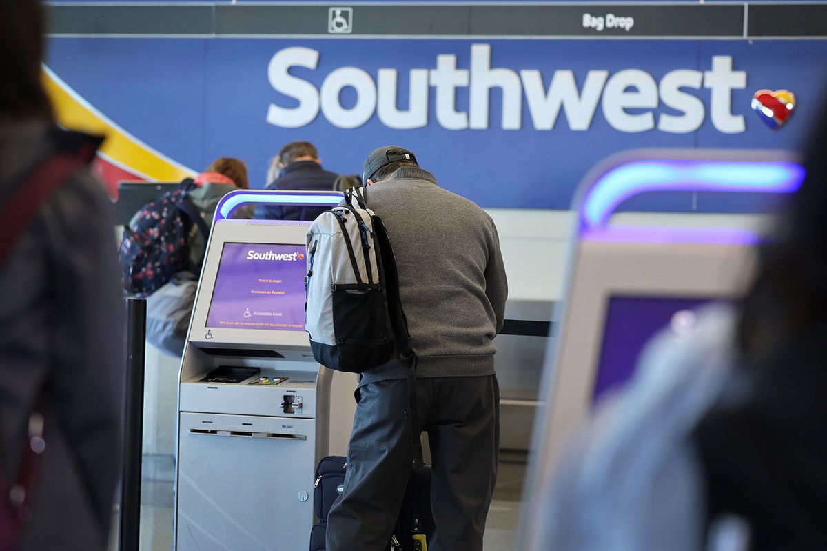 <i>Scott Olson/Getty Images/File via CNN Newsource</i><br/>Passengers check in for Southwest Airlines flights at Chicago Midway International Airport in April 2023. The Department of Transportation is suing Southwest Airlines over 2 