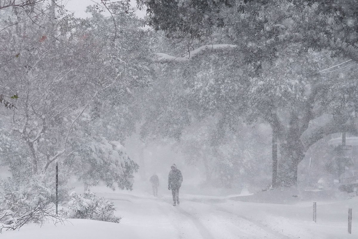 <i>Danielle Villasana/Getty Images via CNN Newsource</i><br/>A man bikes along Sabine Street Bridge near downtown as a winter storm brings heavy bands of snow and sleet Tuesday in Houston.