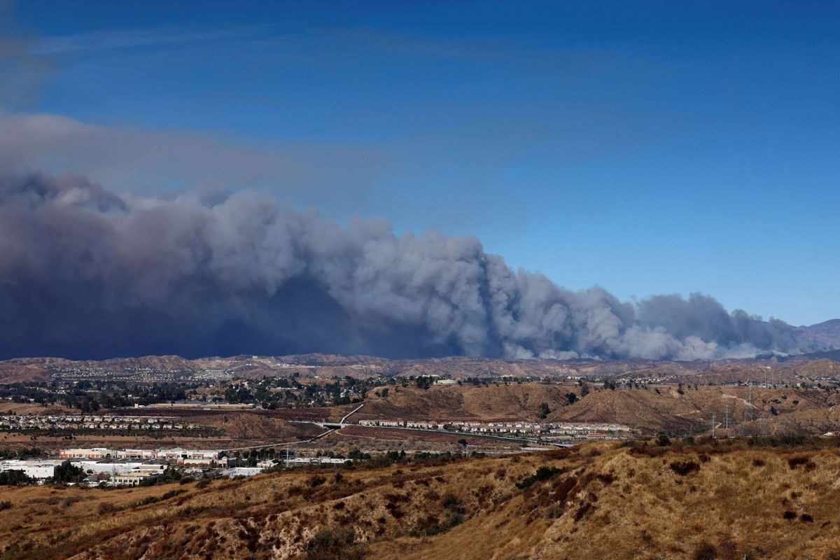 <i>David Swanson/Reuters via CNN Newsource</i><br/>A cloud of smoke from the Hughes Fire rises as firefighters and aircraft battle it near Castaic Lake