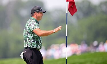 Patrick Reed picks up his ball after carding an albatross on the par-5 fourth at Oakmont Country Club.