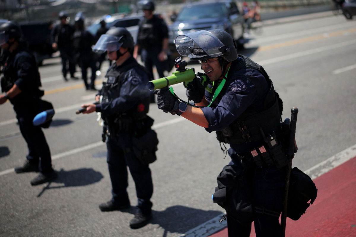 <i>Daniel Cole/Reuters via CNN Newsource</i><br/>A member of the Los Angeles Metro Police fires a rubber bullet during a protest against federal immigration sweeps in downtown Los Angeles on Sunday.
