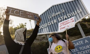 A small group of demonstrators protests outside the entrance of Dodger Stadium on Thursday