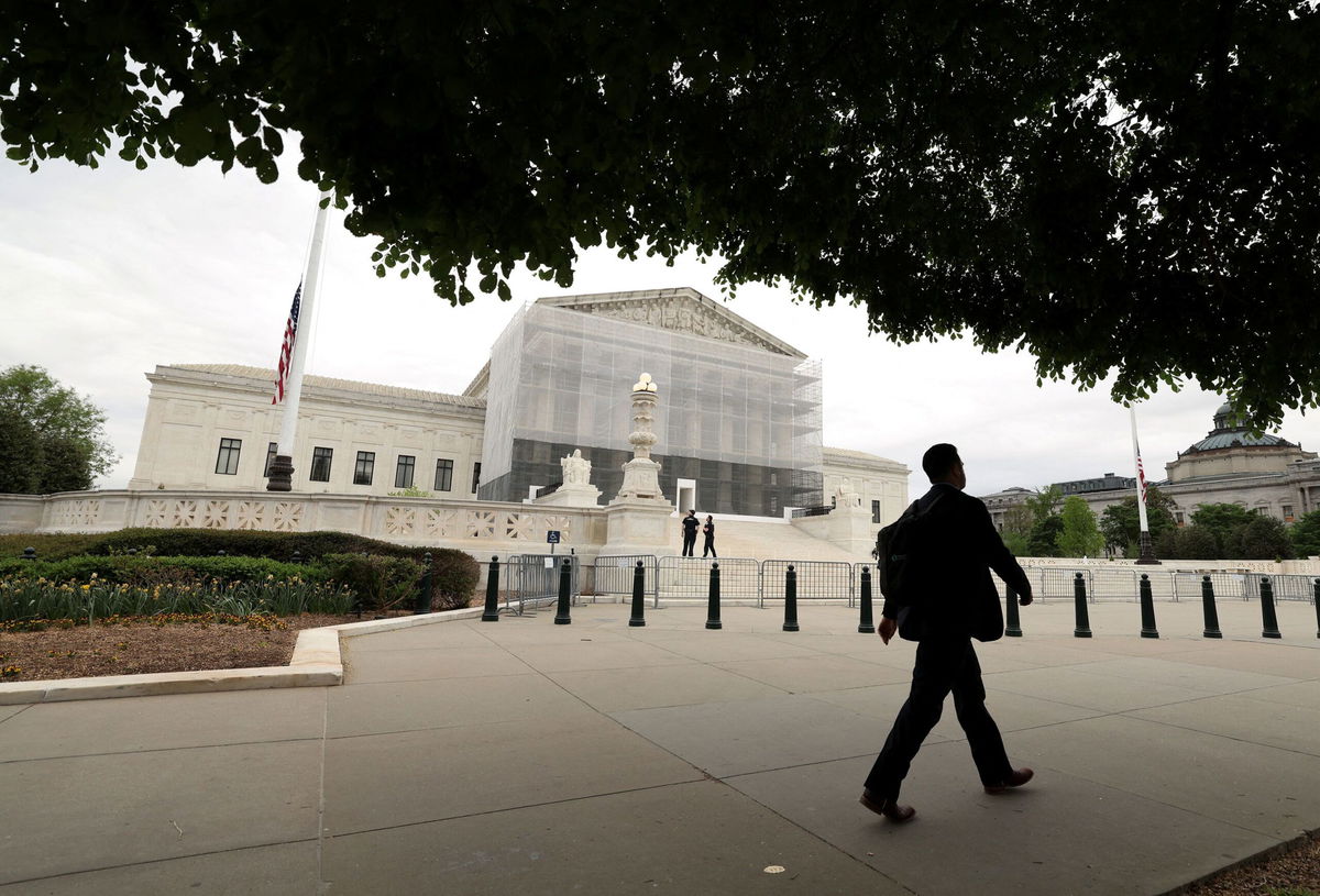 <i>Kevin Lamarque/Reuters via CNN Newsource</i><br/>A person walks past the U.S. Supreme Court in Washington
