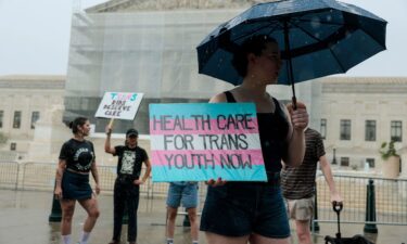 A protester holds a sign in support of gender-affirming care for transgender youth outside of the U.S. Supreme Court Building on June 18