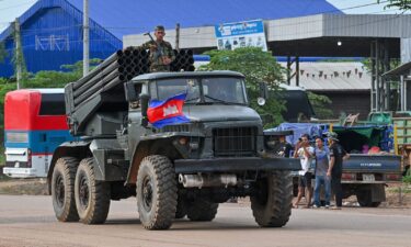 A Cambodian soldier stands on a truck carrying a Russian-made BM-21 rocket launcher travelling along a street in Oddar Meanchey province on July 25.