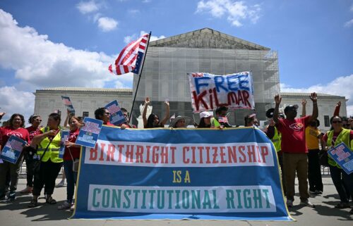 People hold a banner as they participate in a protest outside the US Supreme Court over President Donald Trump's move to end birthright citizenship.
